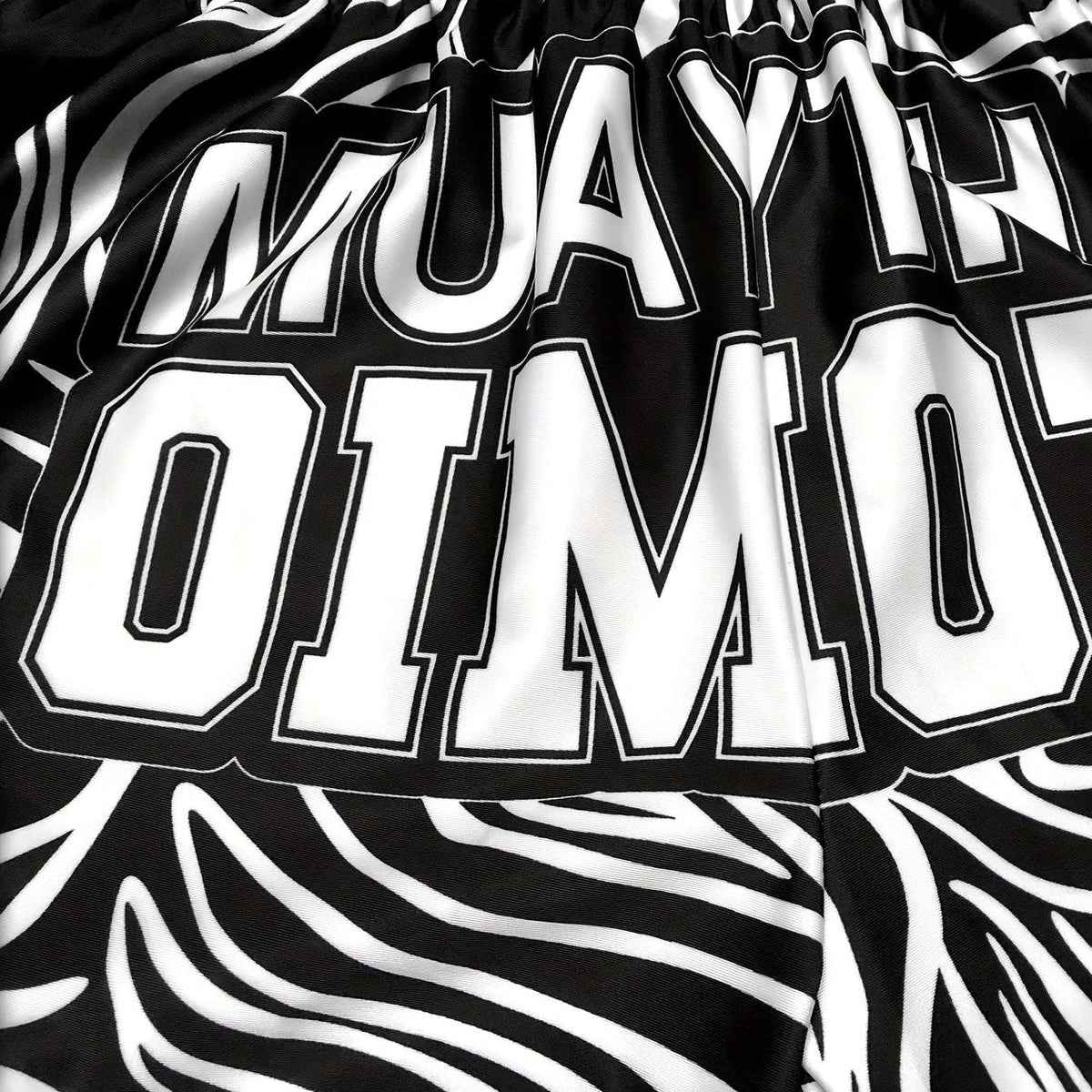 Short muay thai OIMOTI Malay-Blanc/Noir Nakmuay